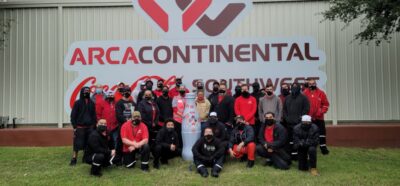 Abilene frontline heroes in front of the Arca Continental CCSWB sign with the Recognition Roadtrip Bottle on Nov. 8, 2021. Arca Continental, the parent company of Coca-Cola Southwest Beverages, is excited to celebrate the 5-year anniversary of CCSWB.