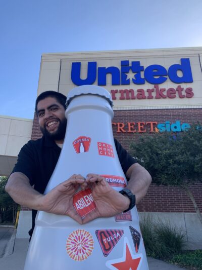 Erik Santiago, Sales Development Manager, outside United Supermarkets – one of Abilene’s largest clients - with the Recognition Roadtrip Bottle.