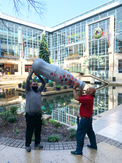 David Espinoza, Order Replenishment Merchandiser Lead, and Troy Perkins, Sales Execution Manager, drinking from the Recognition Roadtrip Bottle on Dec. 31, 2021.