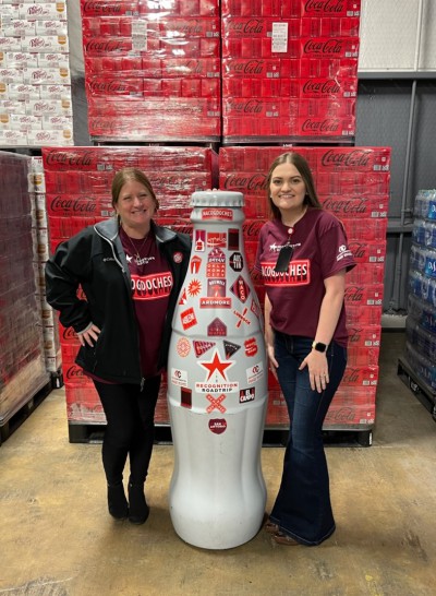 Nacogdoches heroes Kacy Murdock, Market Development Manager (FSOP), and Jordan Noland, Route Process Administrator, show the Recognition Roadtrip Bottle around the Nacogdoches facility on Jan. 20, 2022.