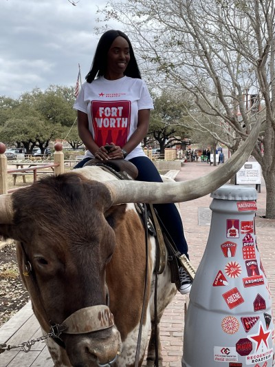 Fort Worth hero Cerita Carpenter, Business Manager, takes a ride on the Texas longhorn alongside the Recognition Roadtrip Bottle in the Stockyards on March 22, 2022.